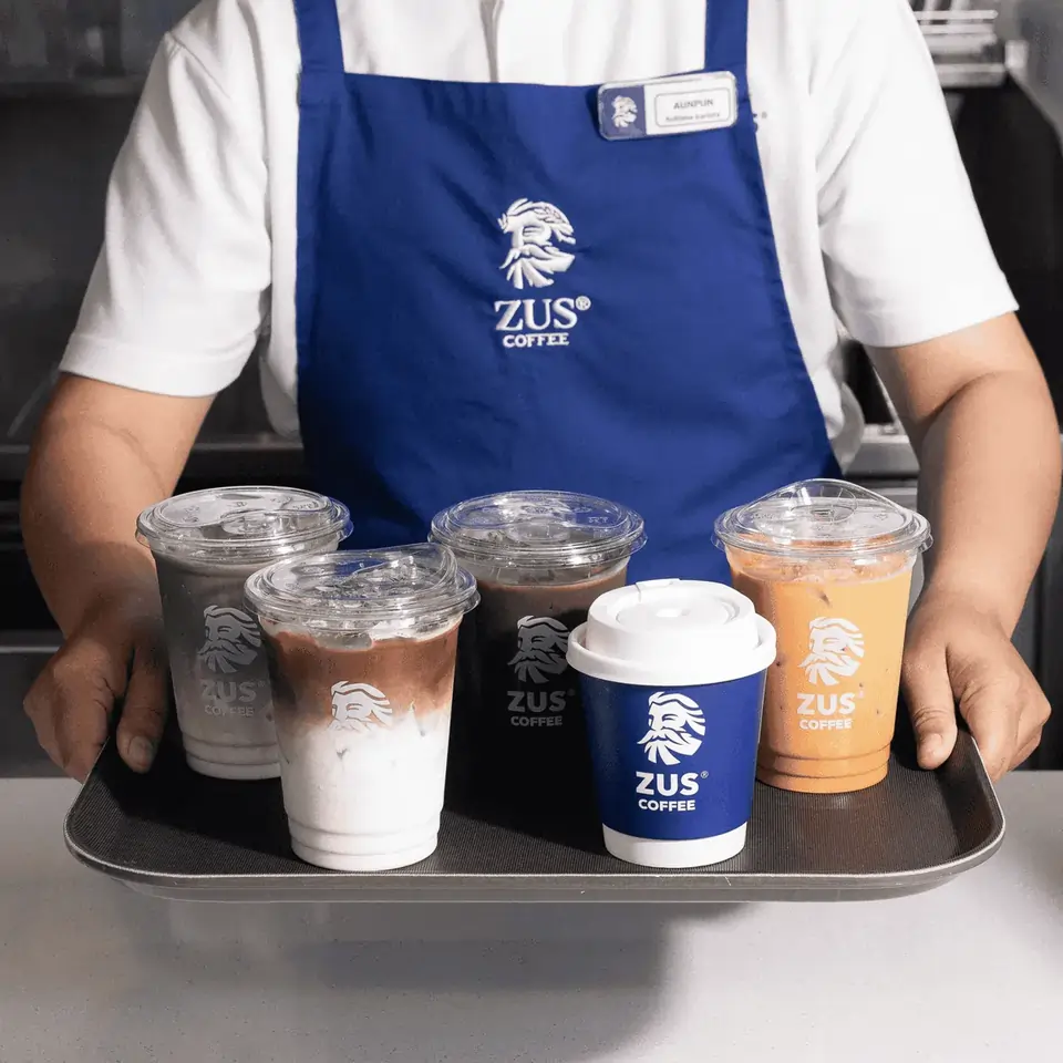 Waiter holding a tray of ZUS Coffee drinks